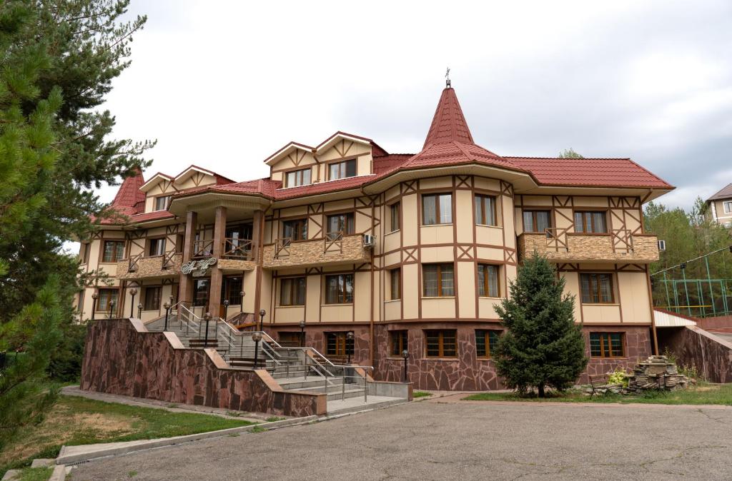 a large building with stairs in front of it at Alpen Ville in Almaty