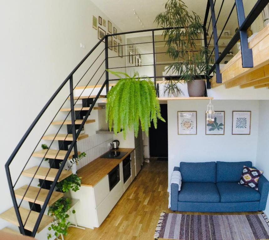 a living room with a blue couch and stairs at Vilnius Cozy Loft in Vilnius