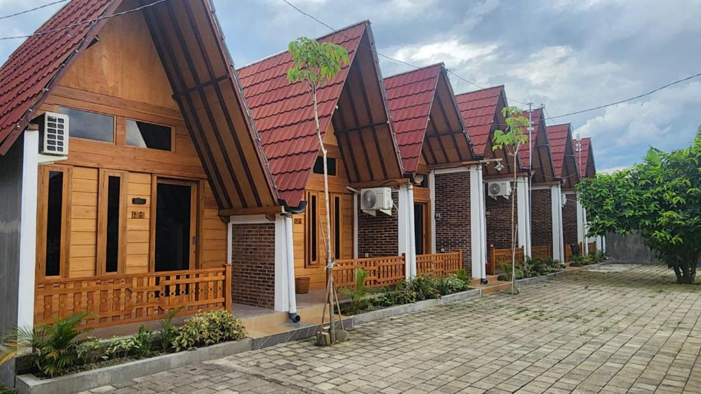 a row of wooden houses with red roofs at Qinoz Villaz in Kedungwaru