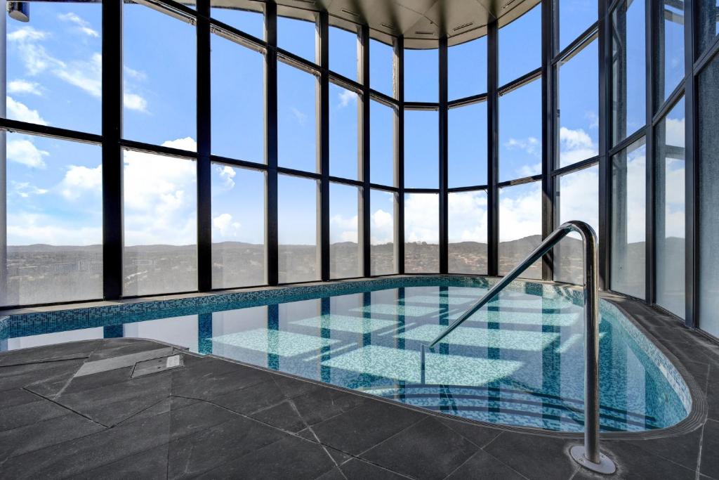 a swimming pool in a building with windows at Chic 1-Bed with Stunning Lake View & Indoor Pool in Belconnen