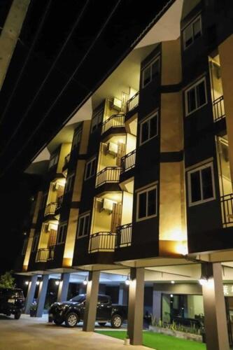a building with a car parked in front of it at Chiang Rai Airport Hotel in Ban Fang Min
