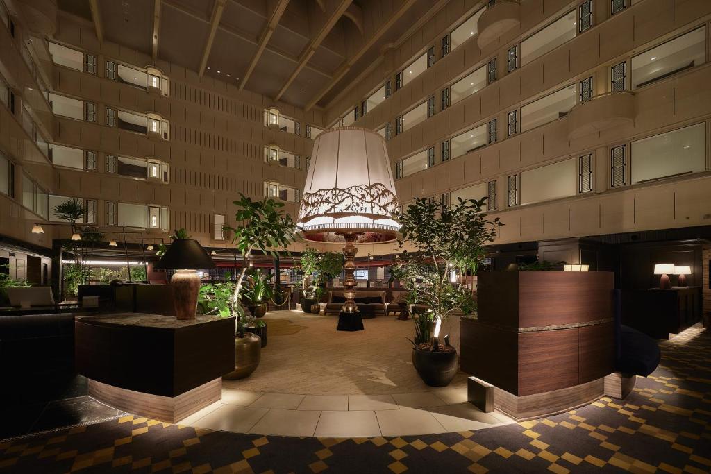 a lobby of a building with potted plants and a chandelier at Kyoto Century Hotel in Kyoto
