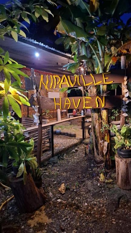 a wooden bench with a sign that says happyiversaryigunigun at Nipaville Haven in Moalboal