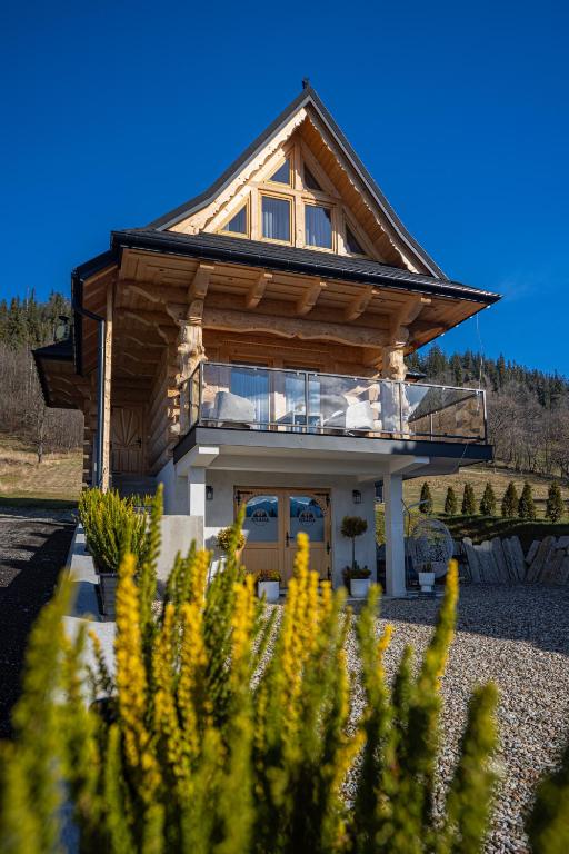 a house with a roof that has a balcony at Osada Poronin in Poronin