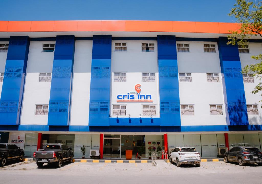 a building with cars parked in front of it at Cris Inn Tagum in Tagum