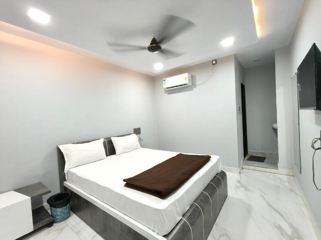 a bedroom with a bed and a ceiling fan at Hotel Rudra in Wākal