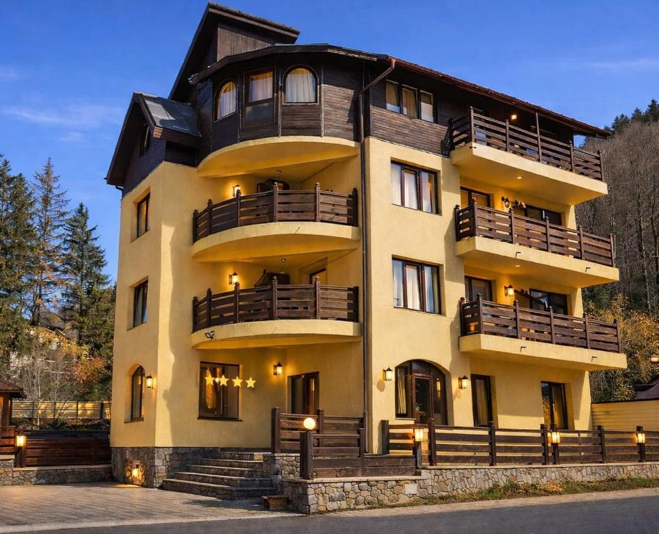a large building with balconies on the side of it at Pensiunea Clasic in Buşteni