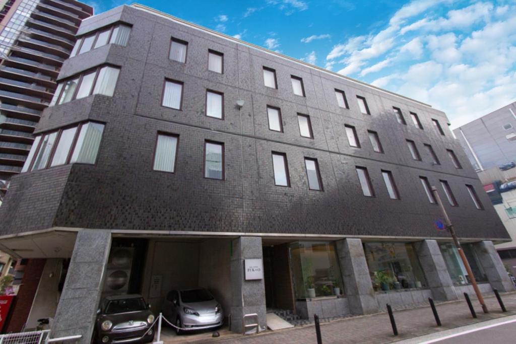 a building with two cars parked in front of it at Hotel FUK O in Fukuoka