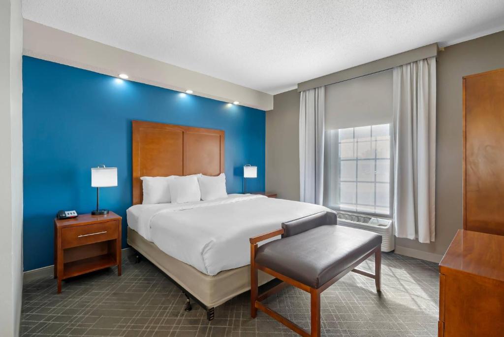 a bedroom with a large bed with a blue wall at Comfort Inn West Monroe near Sports & Events Center in West Monroe