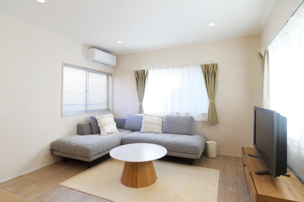 a living room with a couch and a table at JAPANDI HOTEL Nagoya in Chikusachō