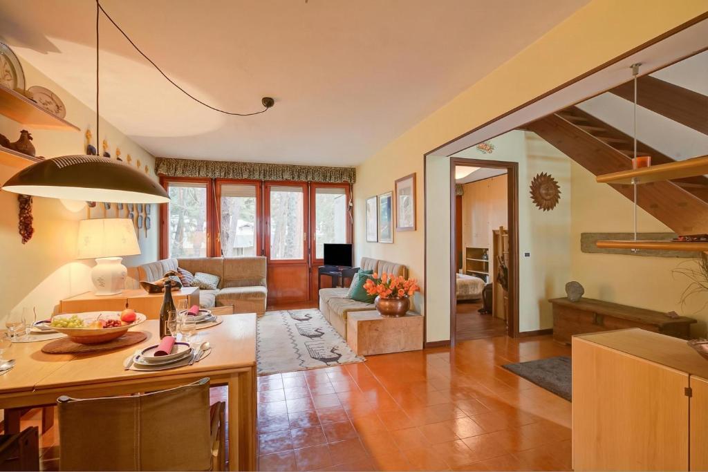a living room with a kitchen and a living room with a staircase at Lo Stambecco - Duplex for 8 people - Happy Rentals in Bardonecchia