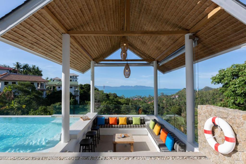 an outdoor patio with a pool and a table and chairs at Luxury Sea View Jungle Beach Villa Walk to Beach in Ban Bang Po