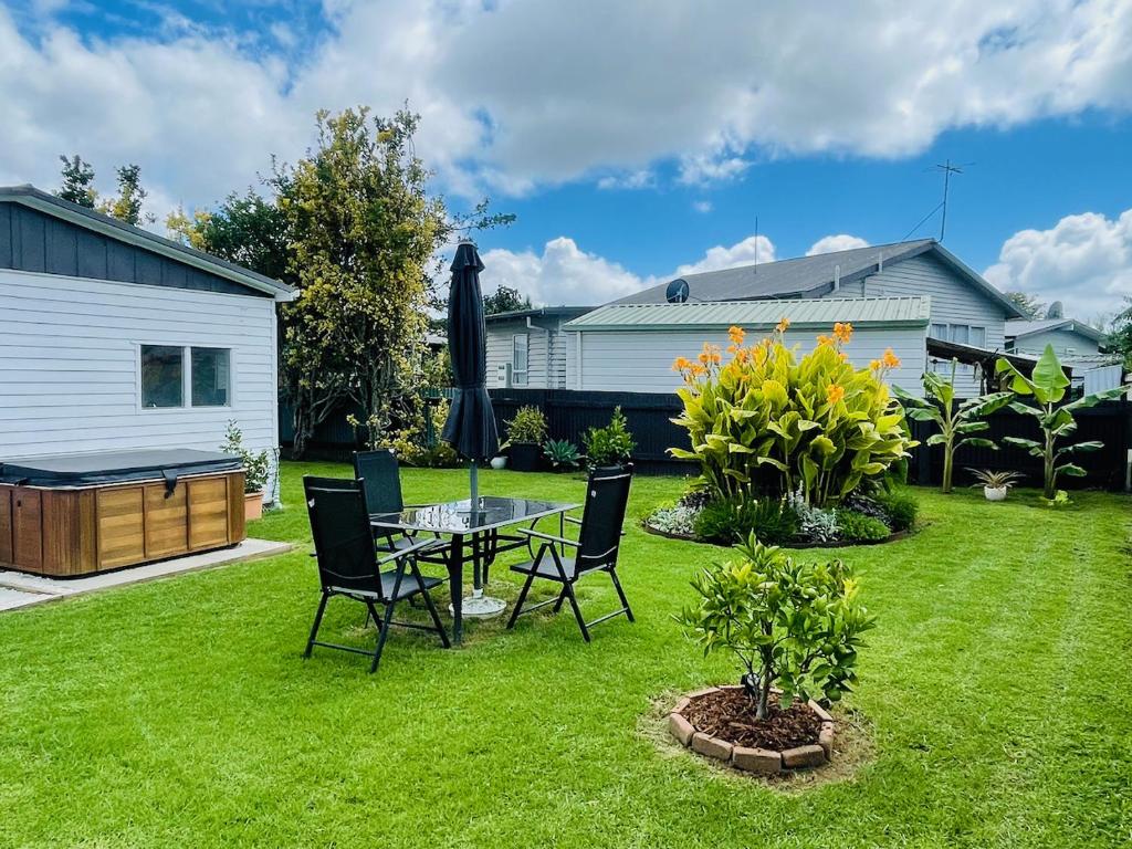 a backyard with a table and chairs on the grass at Private Spa Retreat, Pet-Friendly Whitianga Stay in Whitianga