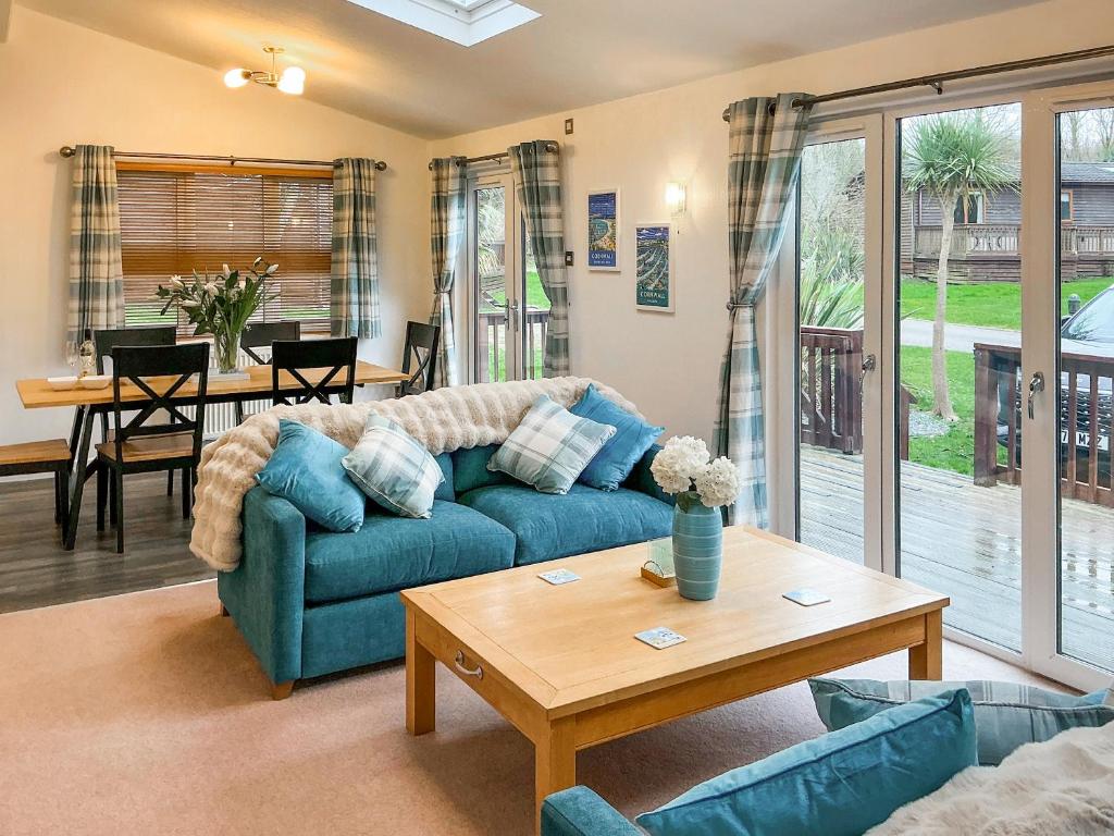 a living room with a blue couch and a table at 9 Trehawks in Roche