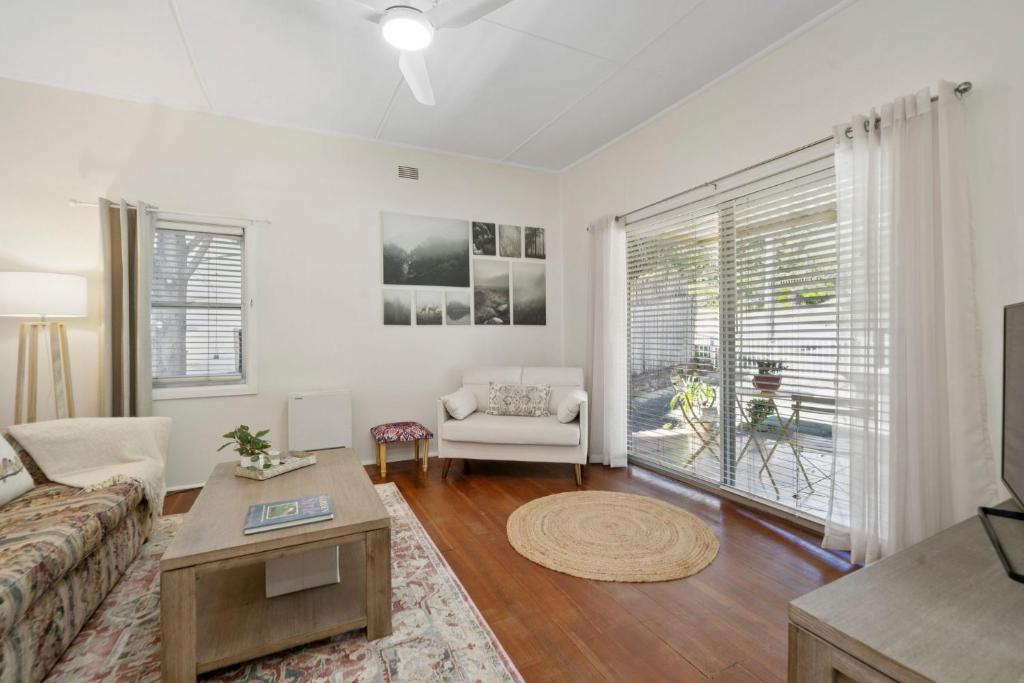 a living room with a couch and a table at Misty Pines in Leura