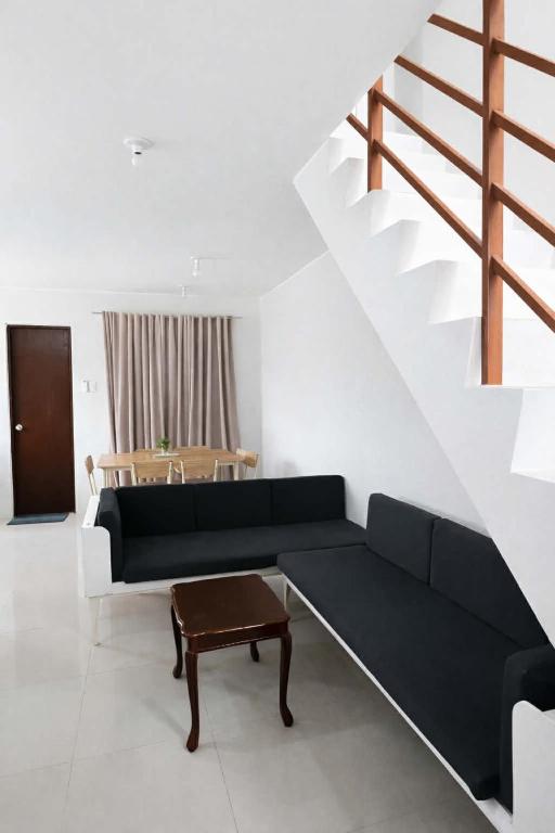 a living room with a black couch and a table at Ben & Ben 1 in Cebu City