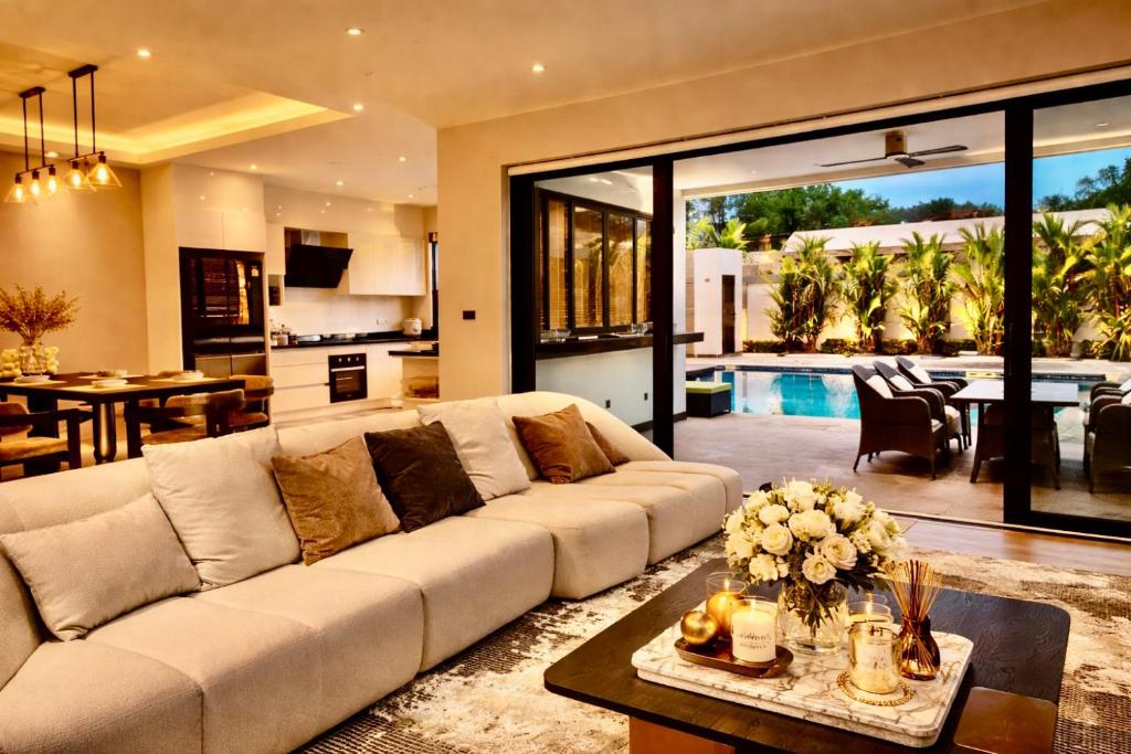 a living room with a white couch and a kitchen at Vantara Villa with Activity Ice Bath in Chiang Mai