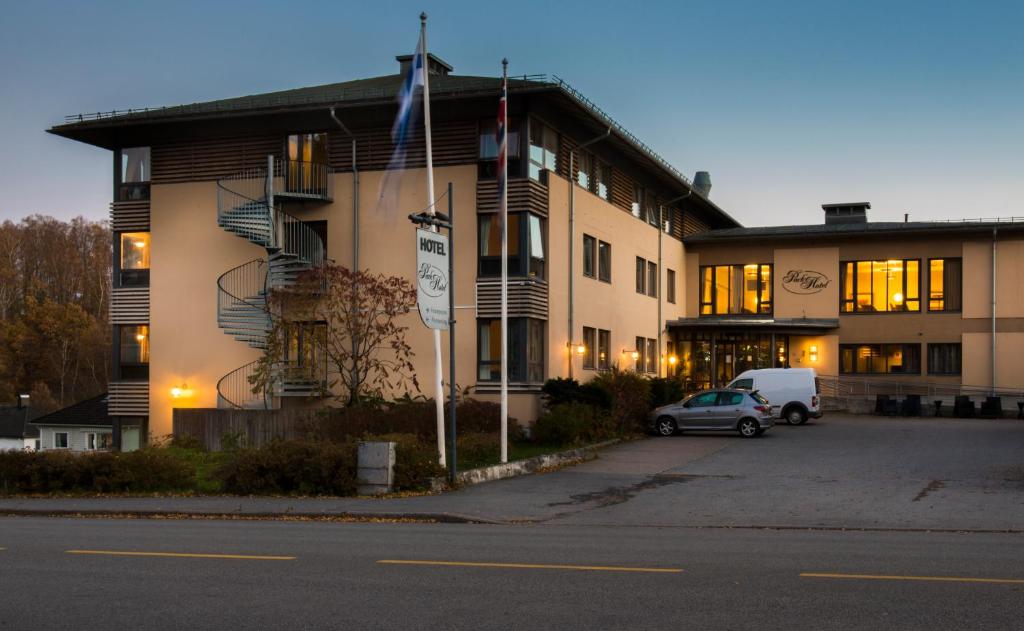 un bâtiment avec une voiture garée devant lui dans l'établissement Clarion Collection Hotel Park, à Halden