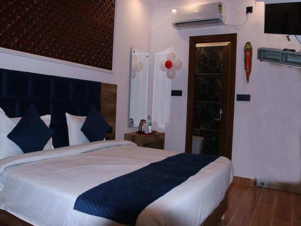 a bedroom with a large bed with blue and white sheets at Red Leaf Hotel in Māler Kotla