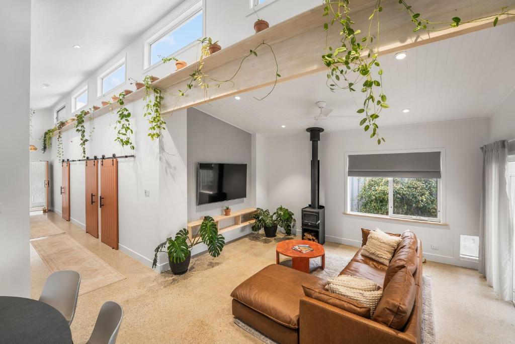 a living room with a couch and a tv at The Ausly Architectural Coastal Retreat with pool pet friendly in Aldinga Beach