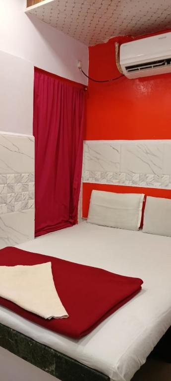 a bedroom with a bed with a red curtain at Hotel firdous in Mumbai