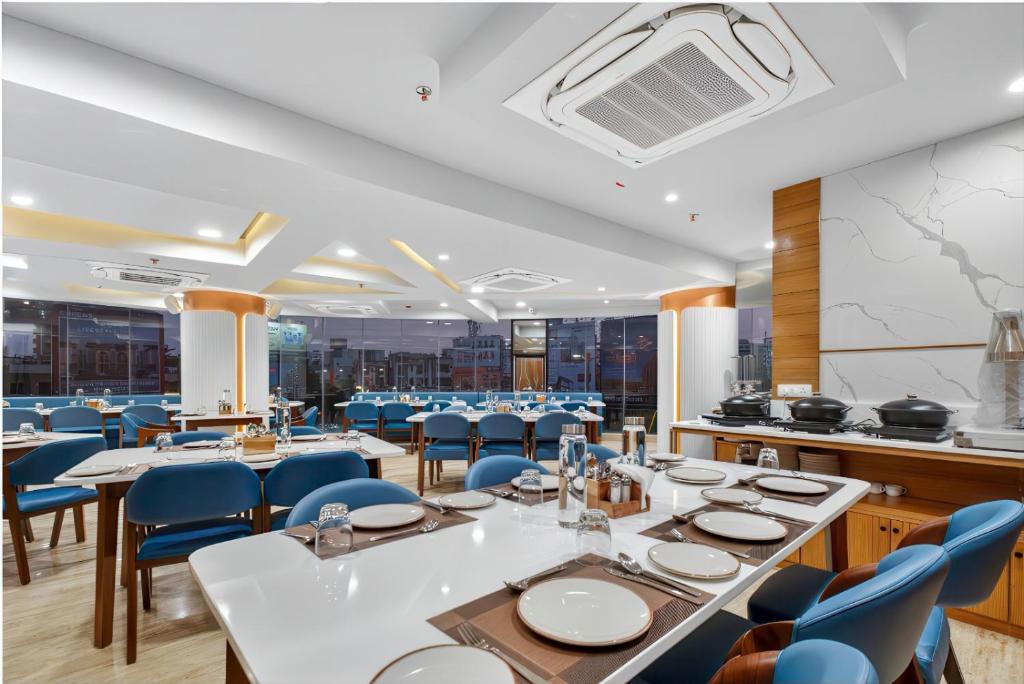 a dining room with tables and blue chairs at Rooms To Go - Indian Guest only in Vadodara