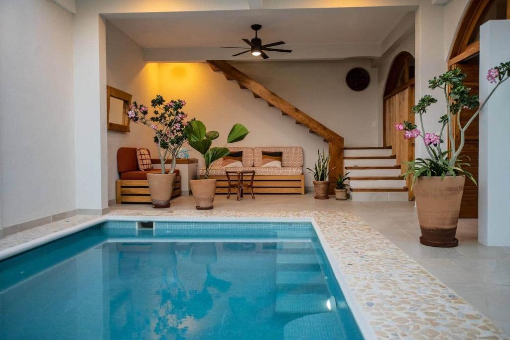 a swimming pool in a living room with a house at Casa Rita! Relaxing two bedroom getaway! in Puerto Escondido