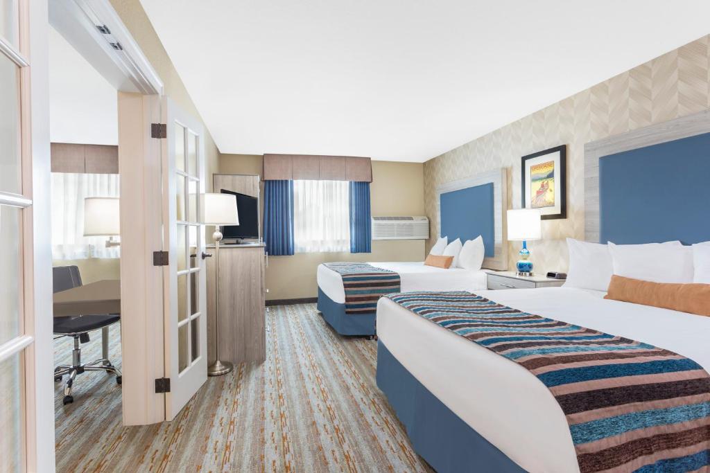 Habitación de hotel con 2 camas y escritorio en SilverStone Inn & Suites Spokane Valley, en Spokane Valley
