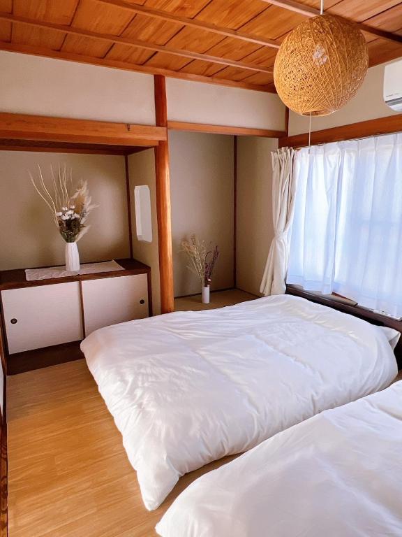 a bedroom with two white beds and a window at 8 Guests Entire Private House in Gifu