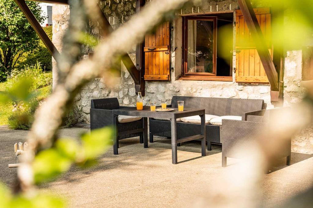 a table and chairs sitting in front of a building at La p'tite Lulu in Le Petit Chenevey