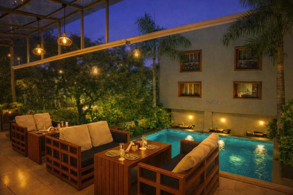 a patio with a table and chairs next to a pool at Hotel Marigold Mount Abu - With Swimming Pool in Mount Ābu