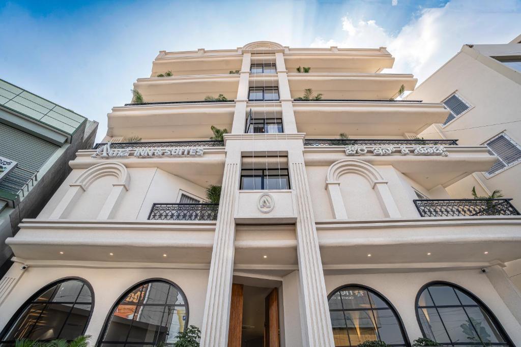 a tall white building with columns at Aura Inn & Suites in Mysore