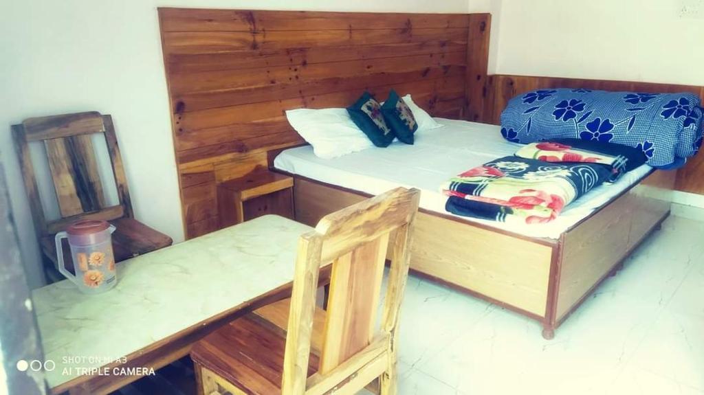 a bedroom with a bed and a wooden wall at Suket homestay in Jhungi