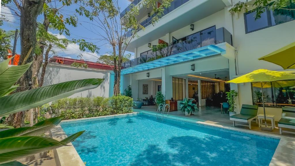 a villa with a swimming pool and a house at Smile Boutique Hotel by EHM in Phnom Penh