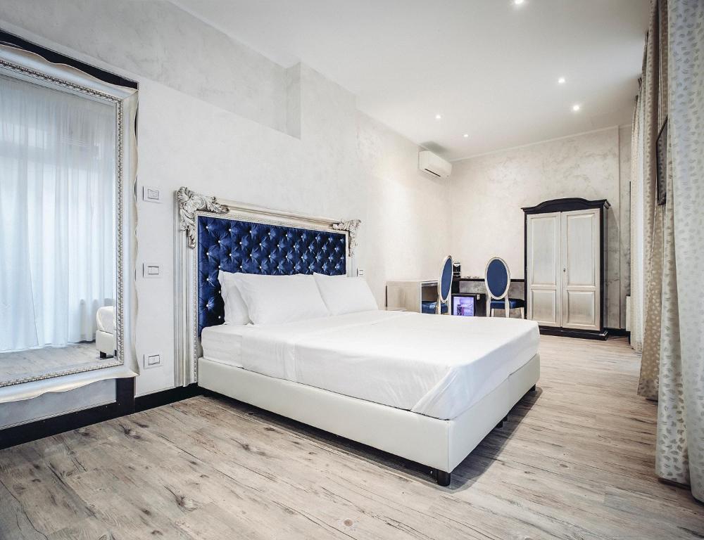 Un dormitorio con una gran cama blanca y una ventana en Arena Easy Suites Guesthouse, en Verona