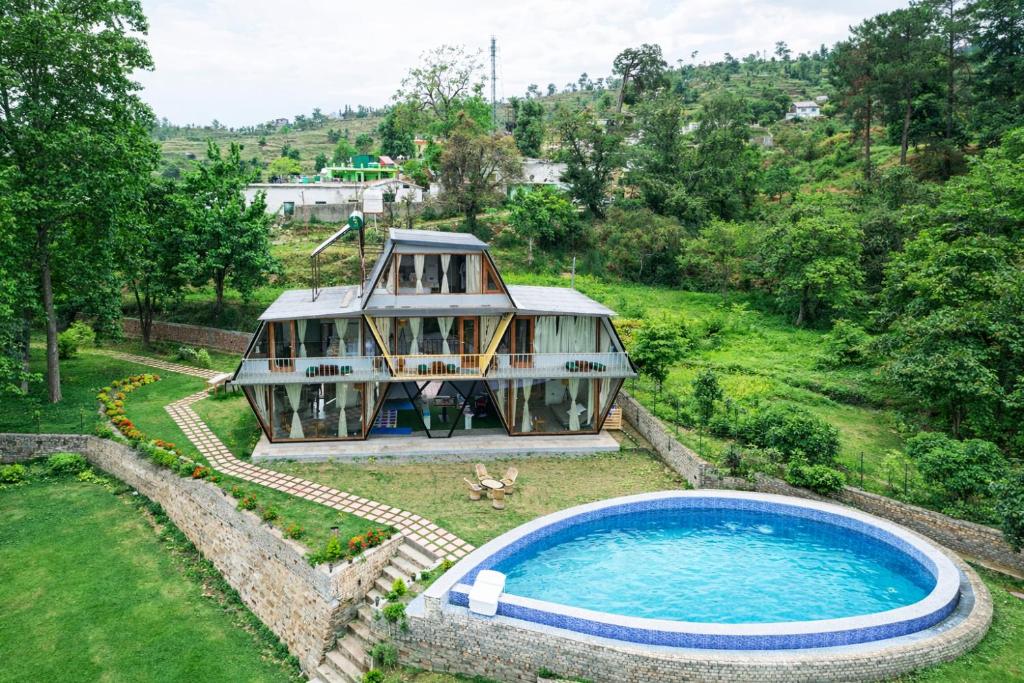 a house with a pool in the yard at Himadvaya- The Himalayan Prism in Almora