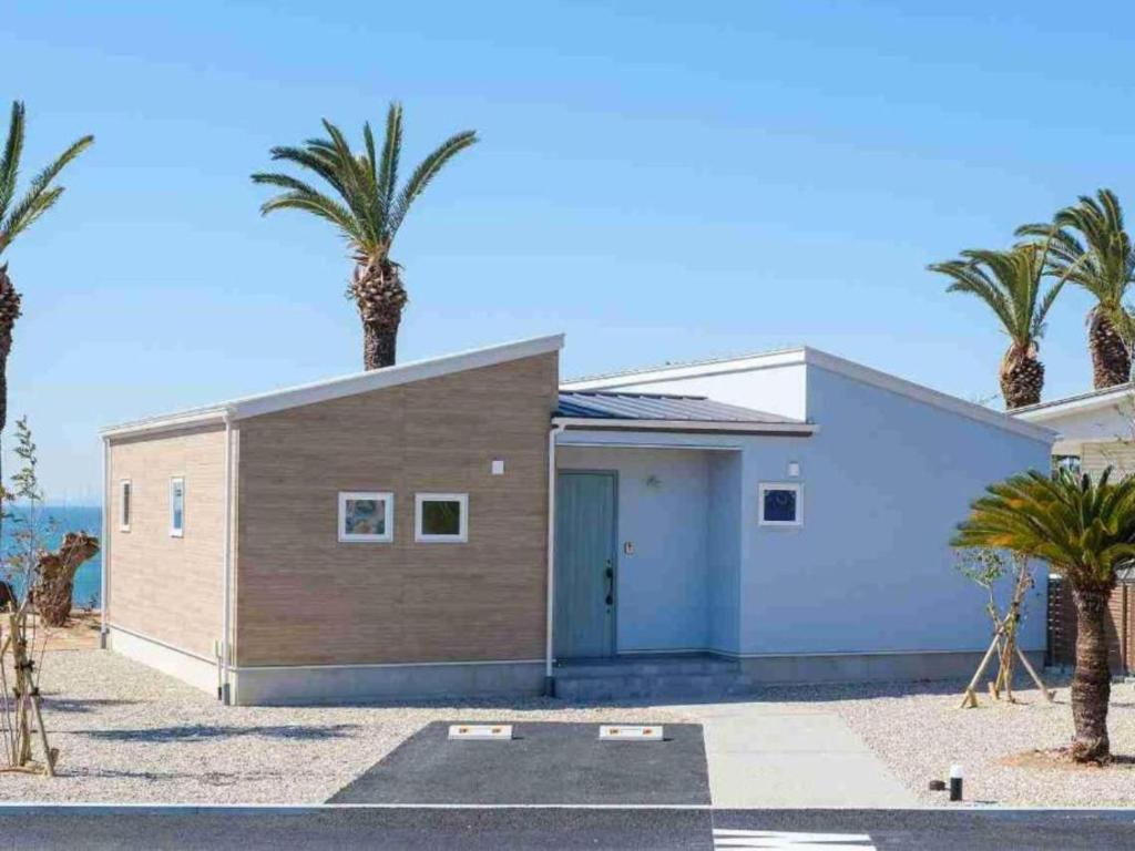 a house with palm trees in front of it at VILLA YAHACHI GARDEN in Tahara
