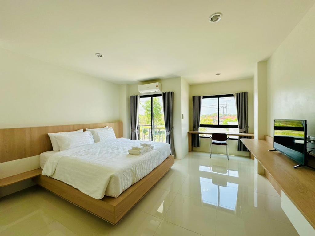 a bedroom with a bed and a desk and a television at SK Residence & resort in Ban Nong Pla Mo