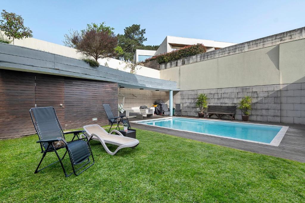a yard with chairs and a swimming pool at Annex Bedroom - Oporto Garden in Porto