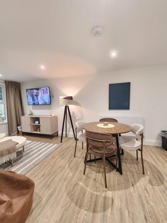 a living room with a table and chairs and a tv at Seashell Retreat in Bournemouth