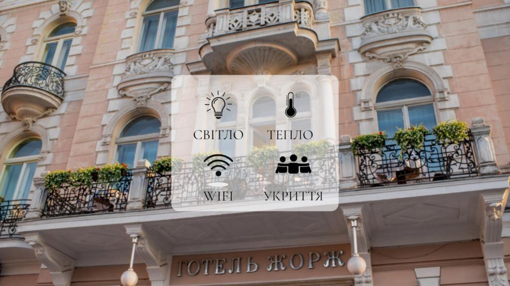 eine Gebäudefassade mit Fenstern und Balkonen in der Unterkunft George Hotel in Lwiw