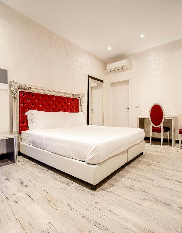 um quarto com uma cama grande e uma cabeceira vermelha em Arena Easy Suites Guesthouse em Verona
