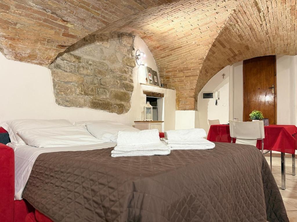 a bedroom with a large bed with a stone wall at Charming Studio with Brick Vaulted Ceilings in Perugia