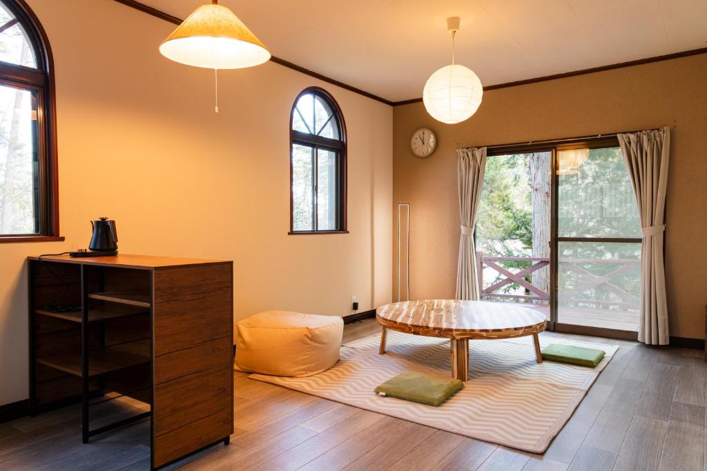 a living room with a table and a coffee table at -貸切別荘-源泉かけ流し温泉 あずみ野ガレージヴィラ-1日1組限定- in Azumino