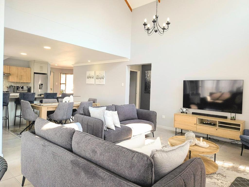 a living room with couches and a flat screen tv at Belo Villa Clarens in Clarens