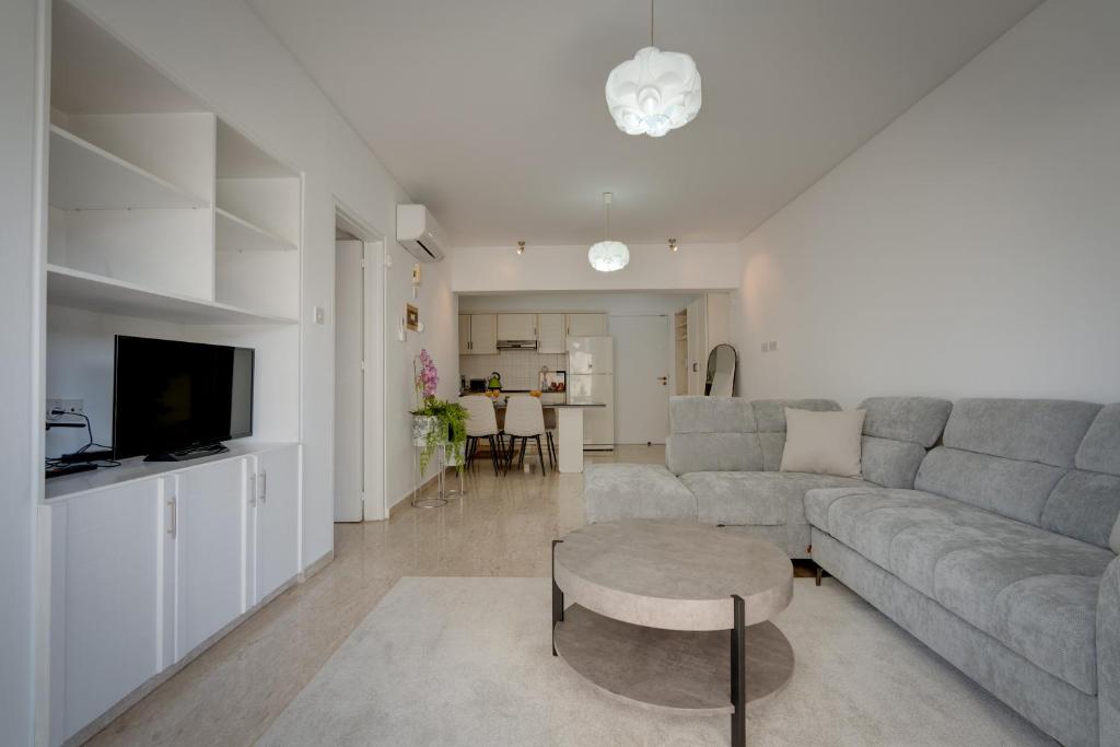 a living room with a couch and a table at Aphrodite Limassol Apartment in Limassol