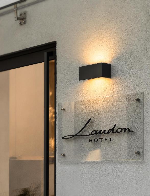 ein Schild für ein Hotel an der Seite eines Gebäudes in der Unterkunft Hotel Laudon in Uschhorod