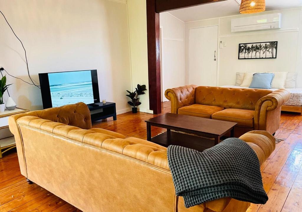 a living room with a couch and a tv at The Mango Shack in Carnarvon