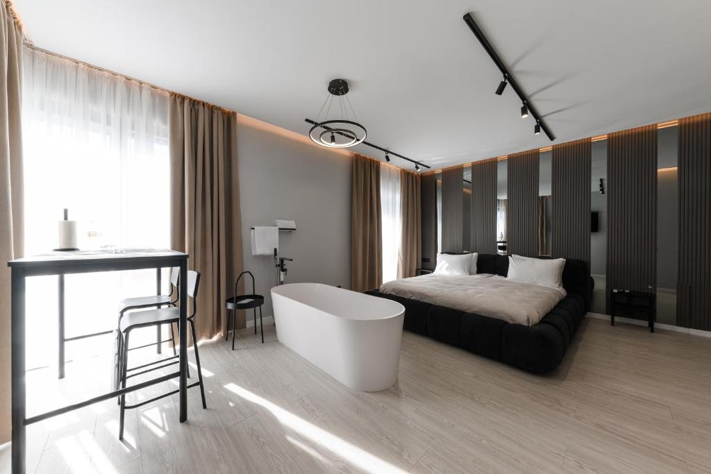 a bedroom with a bed and a tub and a table at MM GROUP APARTMENT Dastor in Uzhhorod