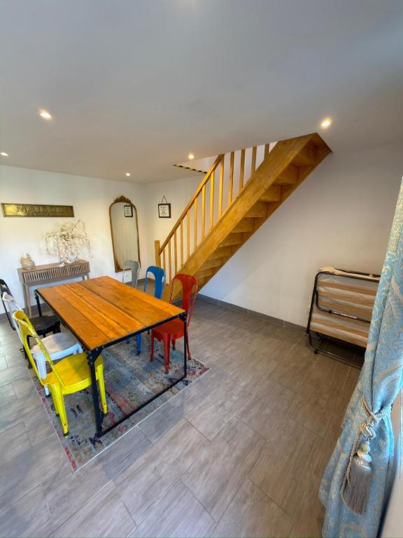 a dining room with a wooden table and chairs at Dans ma Campagne in Mecquignies